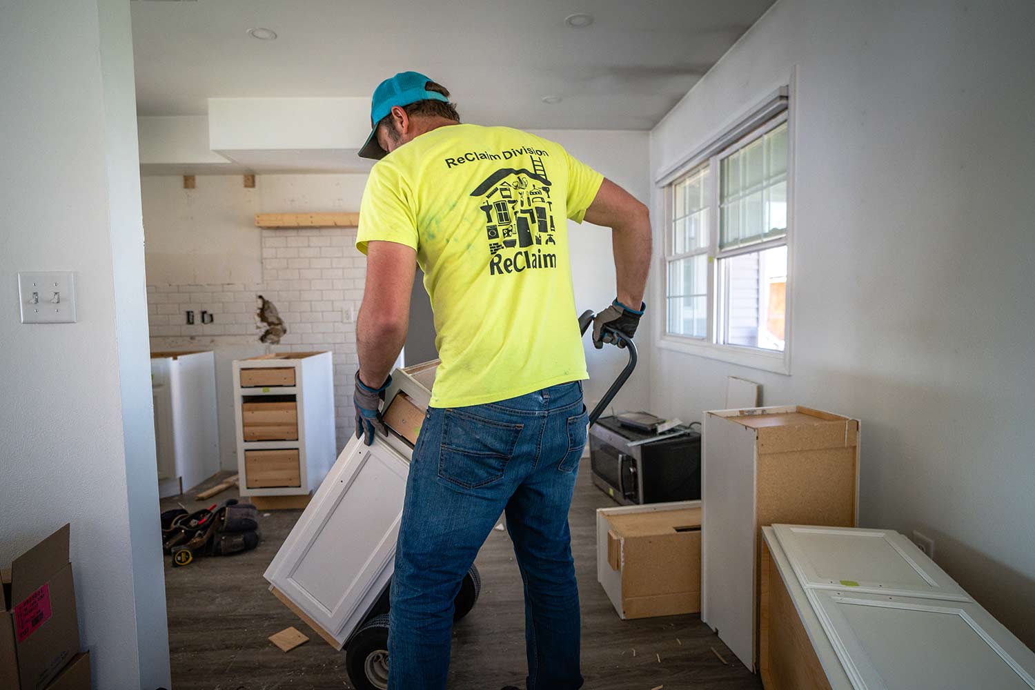 Cabinet installer moving cabinet on a push cart