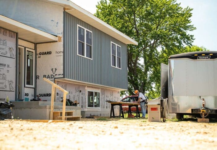 workers installing siding on house