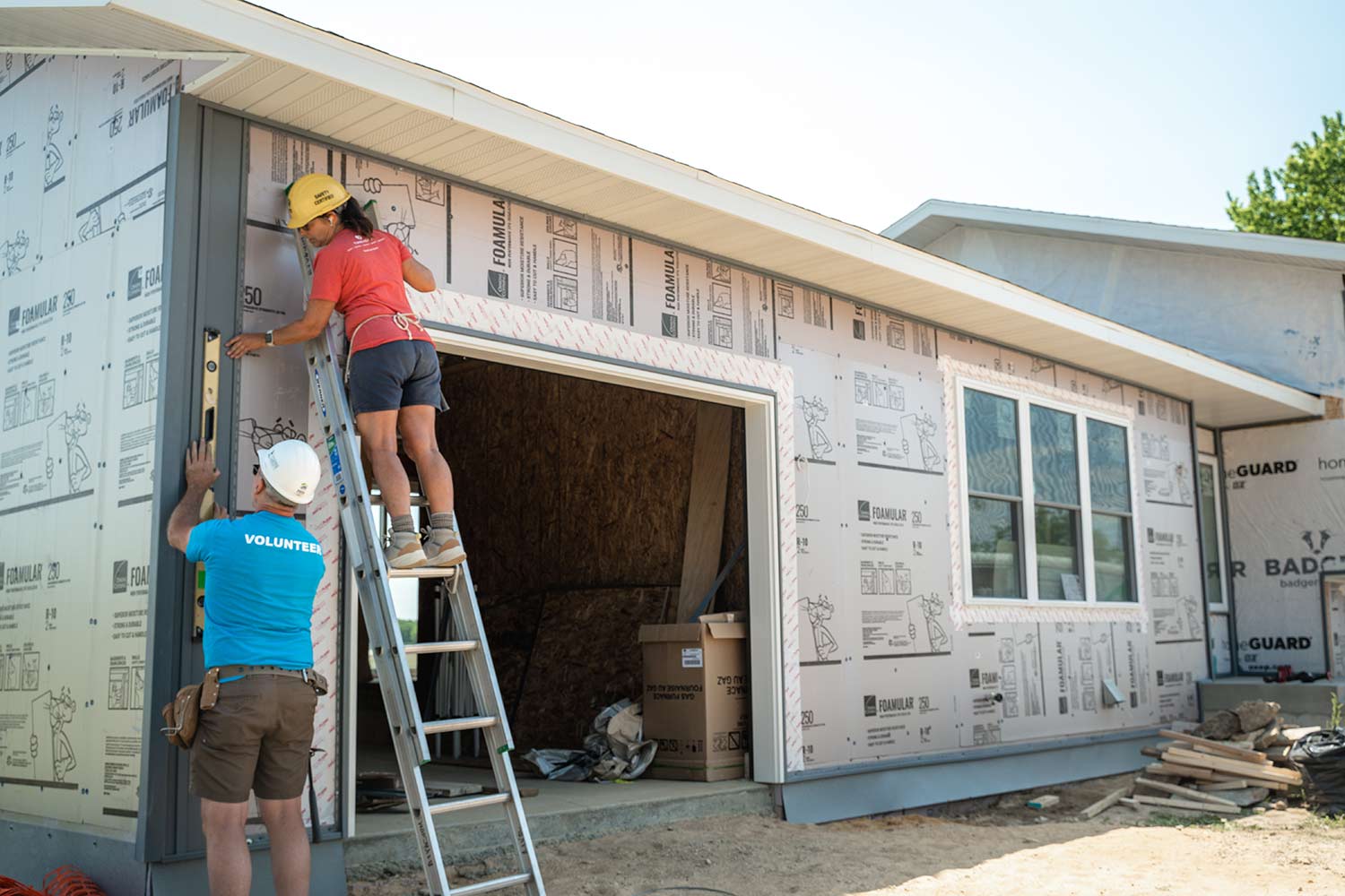 people working on house siding