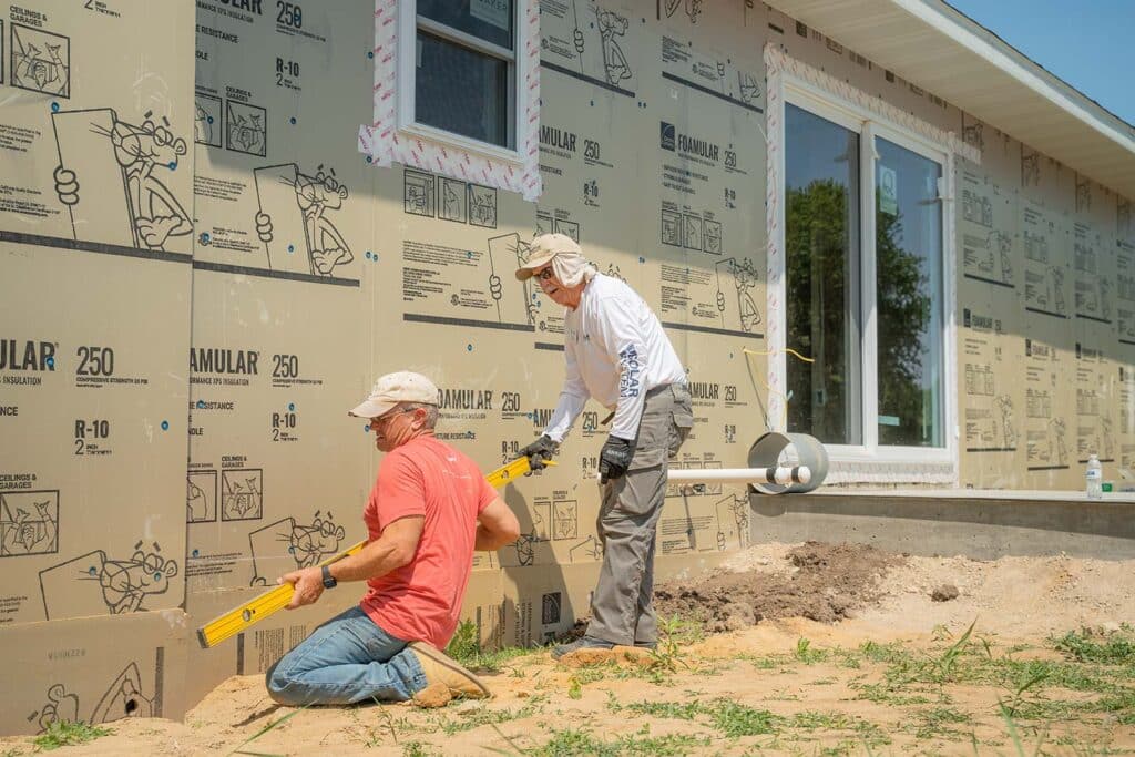 workers siding a house