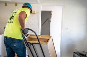 installer moving cabinet on push cart